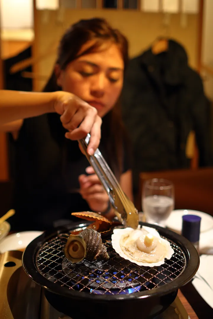 Grilling two scallops and a sea snail (sazae)