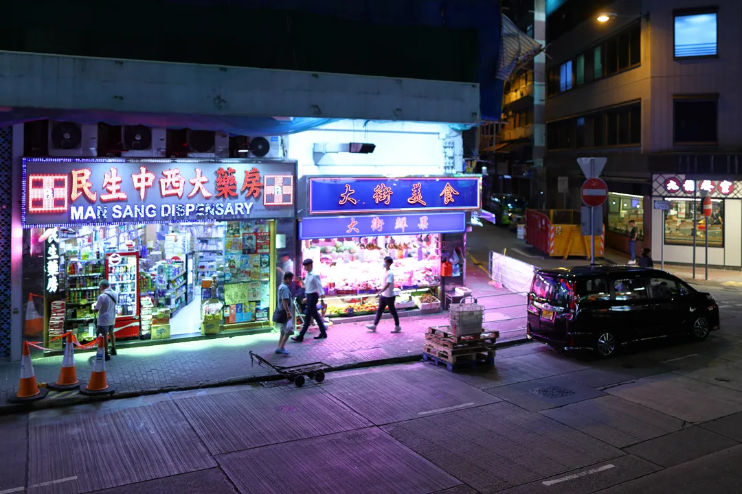 Neon signs of a pharmacy and a grocer