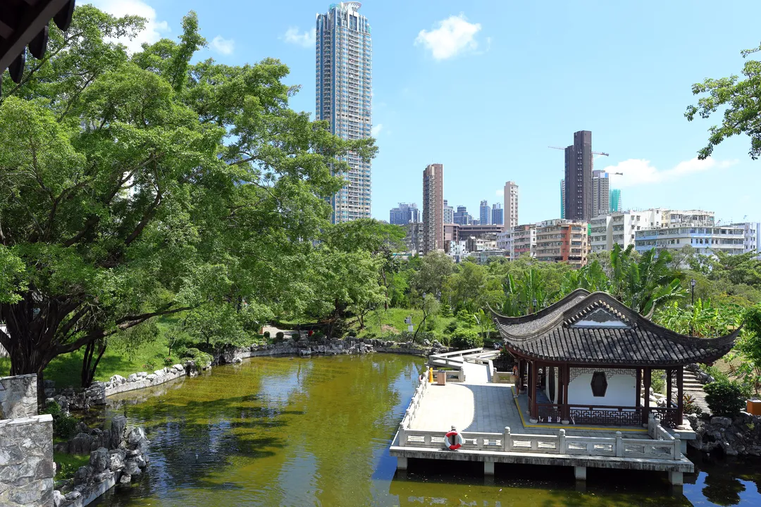 View of Kowloon Walled City Park with high-rises in the background